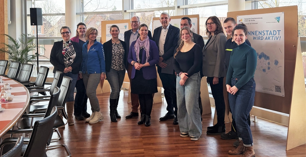 Ministerin Wiebke Osigus steht mit Vertreterinnen und Vertretern der Stadt Osterholz-Scharmbeck und der Landesbeauftragten für regionale Entwicklung Lüneburg Karin Beckmann im Ratssaal der Stadt Osterholz-Scharmbeck. Alle lächeln in die Kamera.